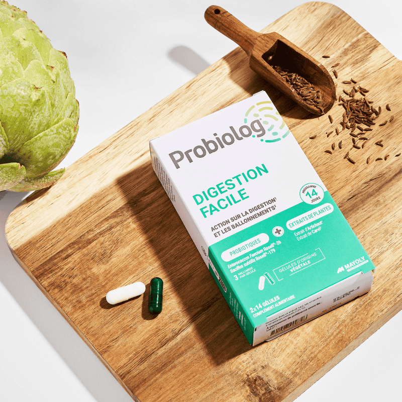Probiolog DIGESTION FACILE sur une planche à découper avec ses 2 gélules par jour et l'artichaut